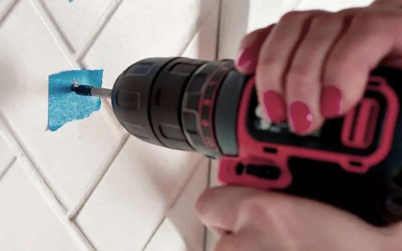 An image showing a homeowner drilling a perfect hole into tile