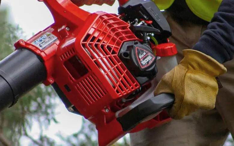 A close up of a petrol powered leaf blower being held