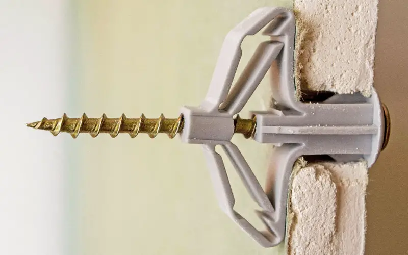 A picture showing a special wall plug anchor being used on plasterboard