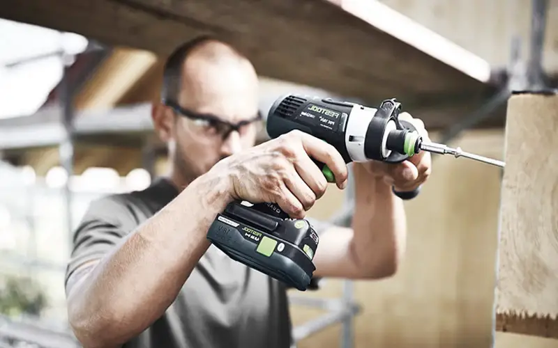 A picture of a DIYer using a combi drill for a project